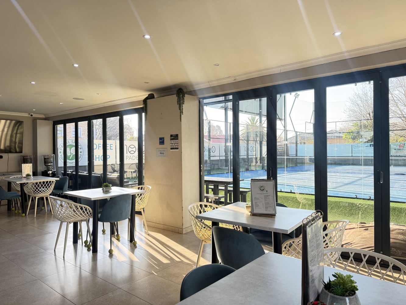 Indoor cafe seating overlooking the Three Rivers padel courts